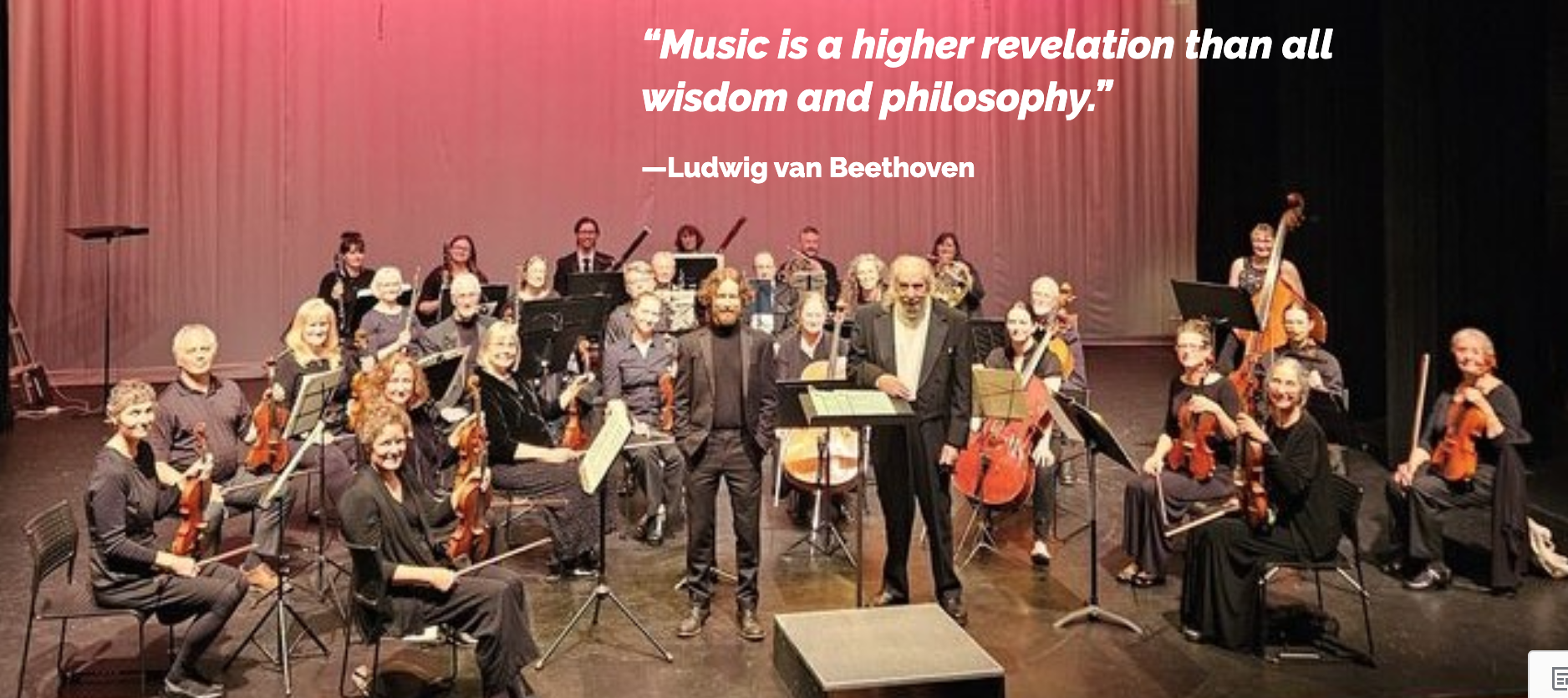 Photograph of an orchestra standing for their bows with inspirational quote